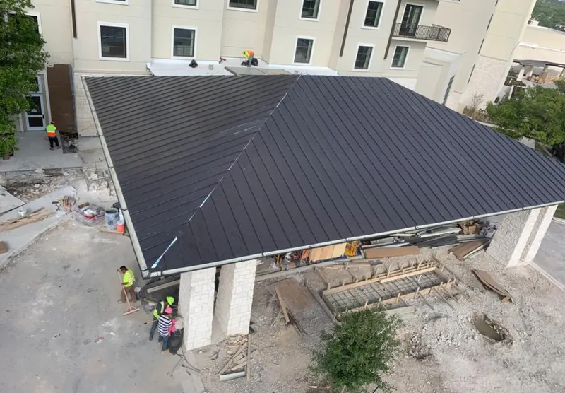 Metal roofing installation team working on a commercial building in Plains